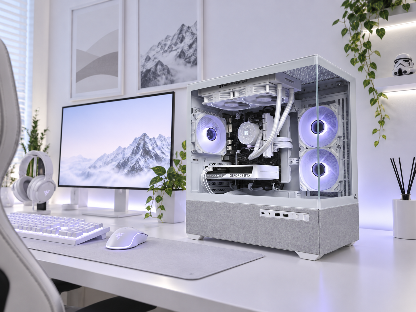 Witte gaming pc met glazen zijpaneel op een bureau met monitor, toetsenbord en muis